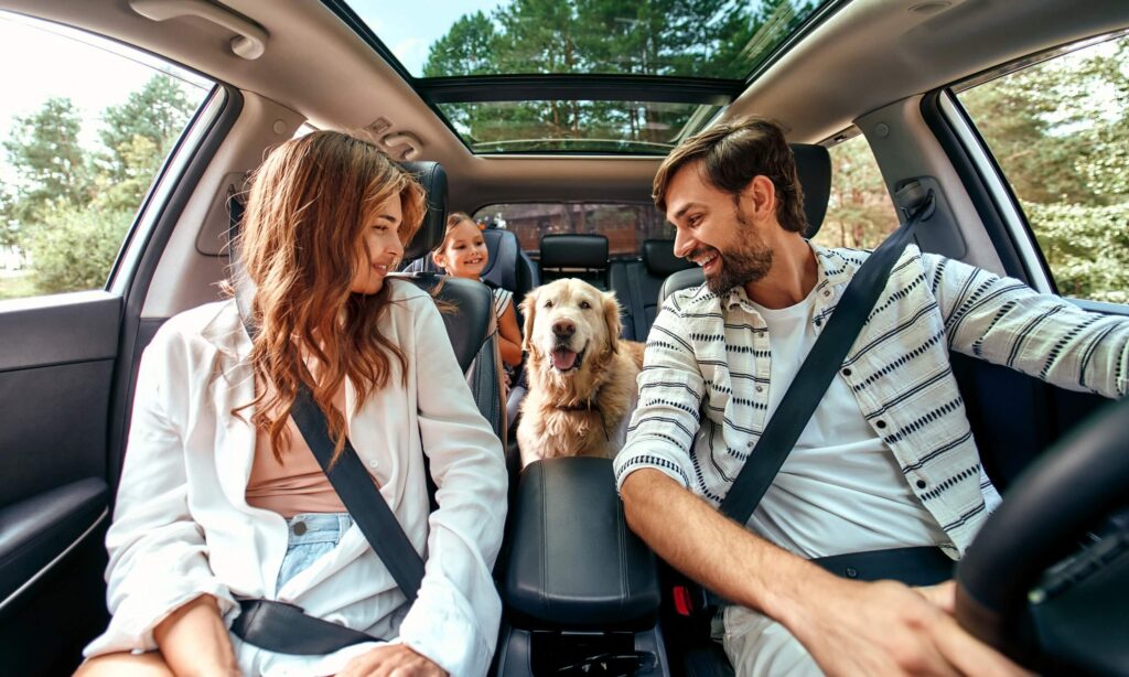 Une famille avec son chien voyage ensemble dans une voiture d'Arval.